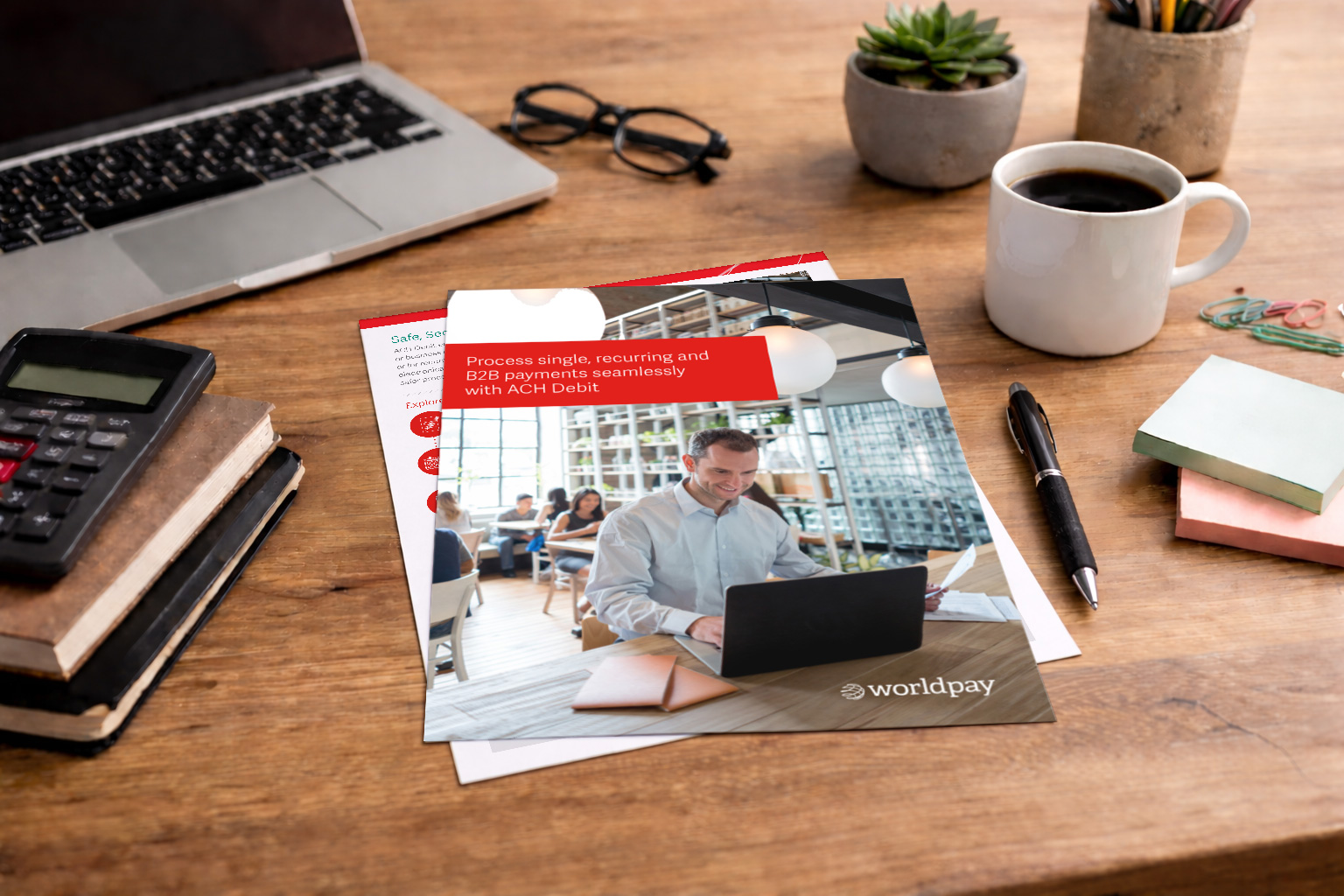 ACH payment processing brochure with professional working on laptop.